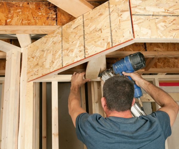 A carpenter is using a pneumatic nailer to install a 2x4” frame bar for a dropped ceiling at a house basement finishing site. http://www.banksphotos.com.c25.sitepreviewer.com/LightboxBanners/ResidentialConstruction.jpg